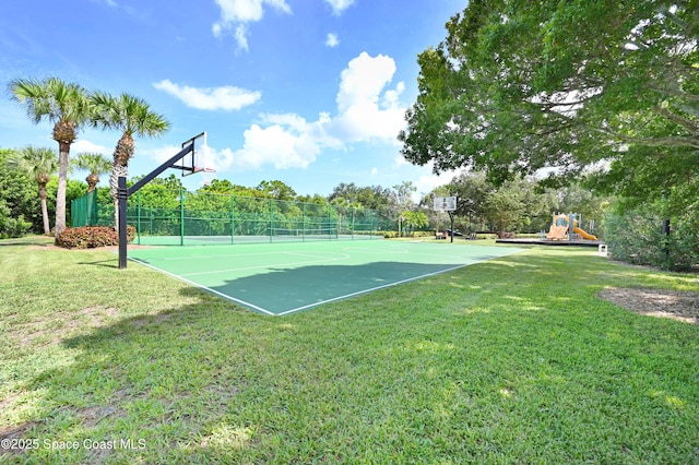 view of basketball court featuring community basketball court, playground community, a yard, and fence