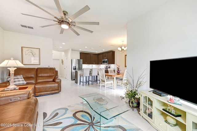 living area with ceiling fan with notable chandelier, light tile patterned flooring, visible vents, and recessed lighting