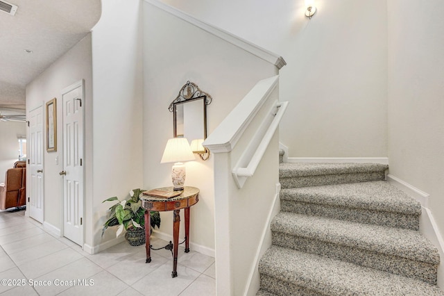 stairs with baseboards, a ceiling fan, visible vents, and tile patterned floors