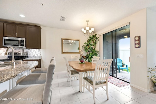 dining room with a chandelier, visible vents, baseboards, and light tile patterned floors