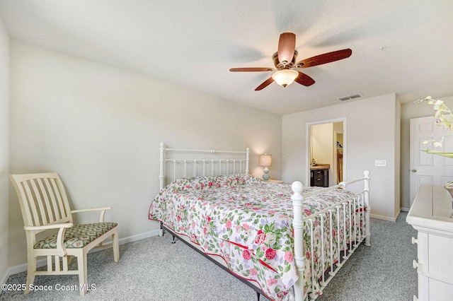 carpeted bedroom with baseboards, visible vents, a ceiling fan, and ensuite bathroom