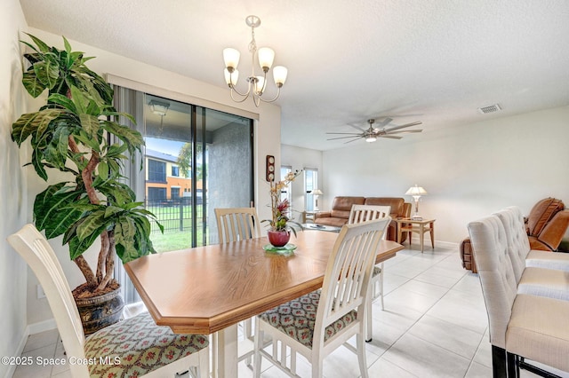 dining space with light tile patterned floors, a textured ceiling, ceiling fan with notable chandelier, visible vents, and baseboards