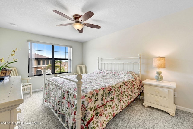 bedroom featuring a ceiling fan, baseboards, a textured ceiling, and light colored carpet