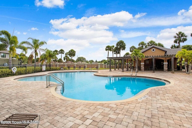 community pool featuring a patio area, fence, and a pergola