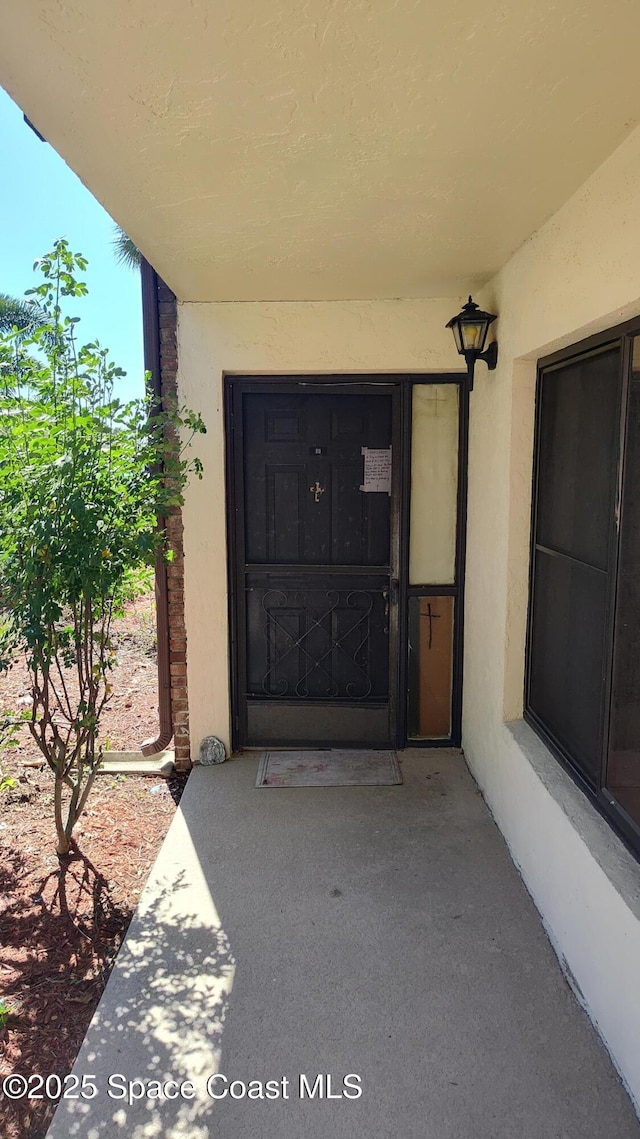 entrance to property featuring stucco siding