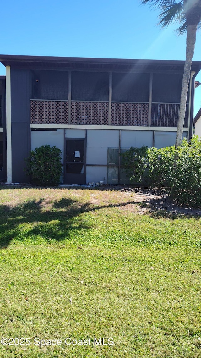 rear view of house featuring a lawn