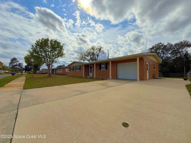 single story home featuring an attached garage, concrete driveway, and a front yard