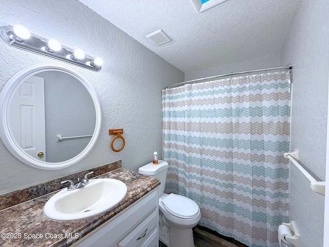 full bathroom with visible vents, a textured wall, toilet, a textured ceiling, and vanity