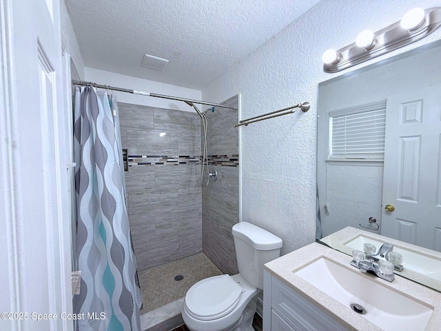 bathroom featuring a textured ceiling, a textured wall, a tile shower, and toilet