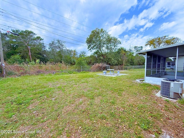 view of yard with a sunroom, a fenced backyard, and central air condition unit