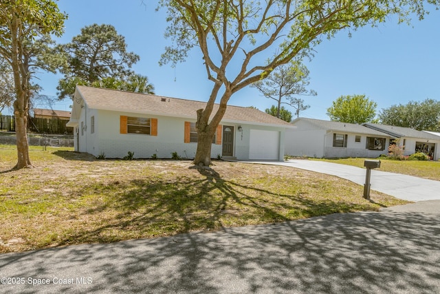 single story home with an attached garage, concrete driveway, and a front yard