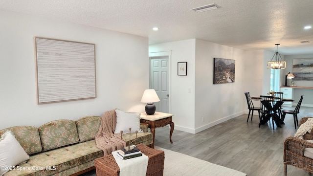1151 Covina St, Cocoa, FL 32927 - living area with a chandelier, light wood finished floors, recessed lighting, a textured ceiling, and baseboards