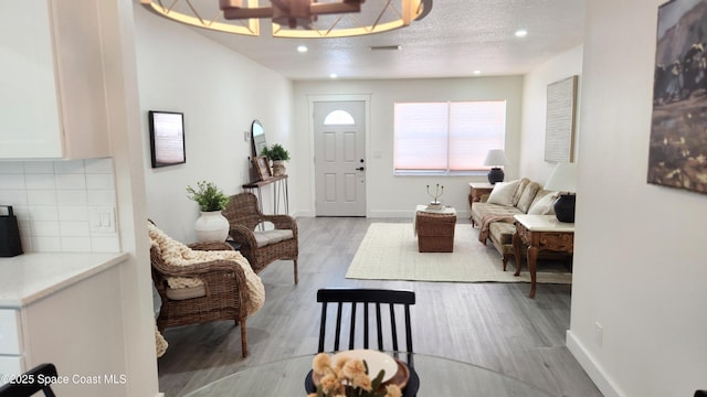 1151 Covina St, Cocoa, FL 32927 - living room with light wood-style floors, baseboards, recessed lighting, and a textured ceiling