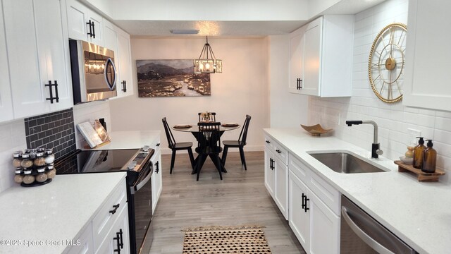 1151 Covina St, Cocoa, FL 32927 - kitchen featuring appliances with stainless steel finishes, a sink, and white cabinetry