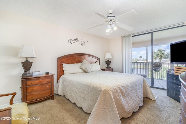 bedroom with carpet floors, access to outside, expansive windows, and a textured ceiling