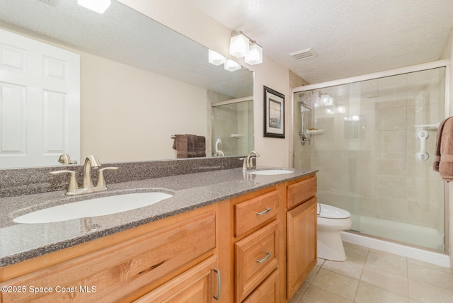 full bath featuring toilet, a shower stall, a sink, and tile patterned floors