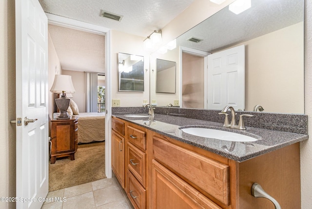 bathroom with visible vents, a sink, and a textured ceiling