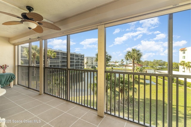 unfurnished sunroom with ceiling fan