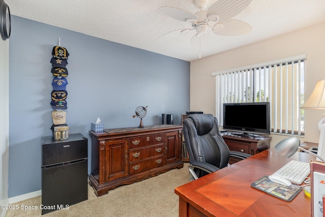 office with a textured ceiling, a ceiling fan, and light colored carpet