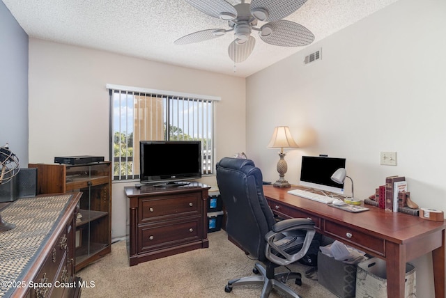 office space featuring a ceiling fan, light colored carpet, visible vents, and a textured ceiling