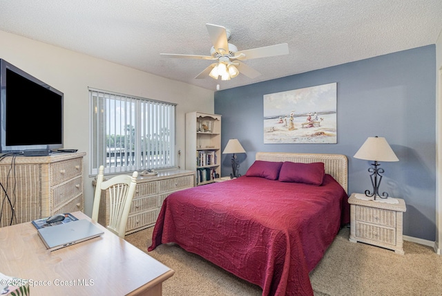 bedroom featuring carpet, baseboards, ceiling fan, and a textured ceiling