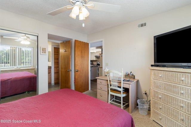 carpeted bedroom featuring a ceiling fan, visible vents, and a textured ceiling