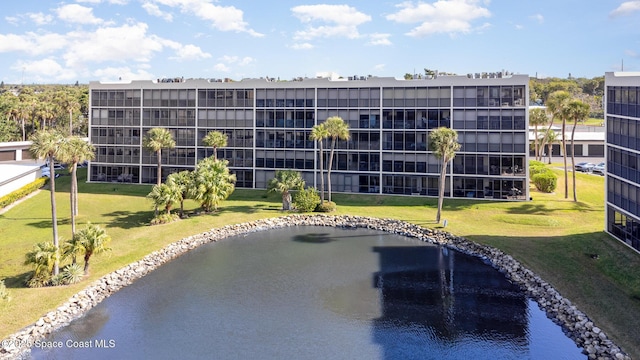 view of swimming pool featuring a water view and a lawn