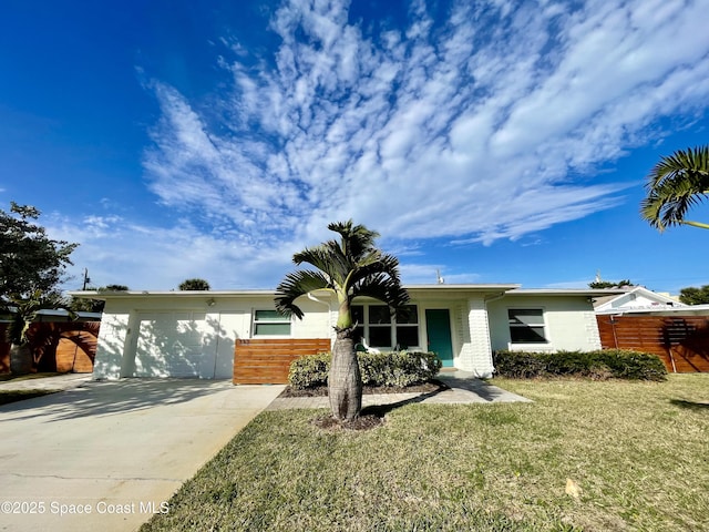 view of front of house featuring concrete driveway, fence, and a front lawn