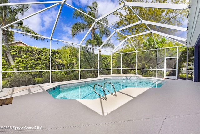 outdoor pool with glass enclosure and a patio