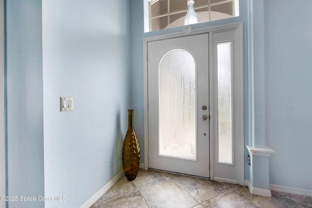 foyer entrance featuring baseboards