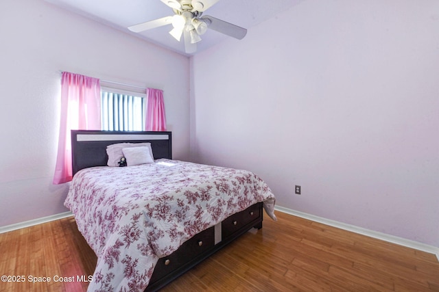 bedroom with wood finished floors, a ceiling fan, and baseboards
