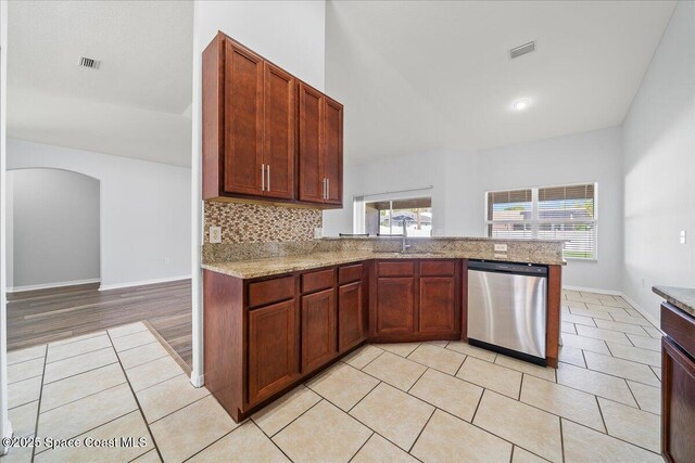 kitchen featuring visible vents, backsplash, stainless steel dishwasher, a sink, and light tile patterned flooring