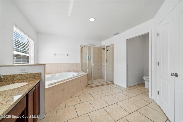 full bathroom featuring a stall shower, vanity, a bath, and tile patterned floors