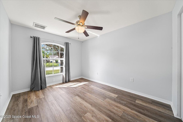 unfurnished room with baseboards, visible vents, ceiling fan, and wood finished floors