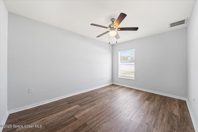 spare room with a ceiling fan, baseboards, visible vents, and wood finished floors