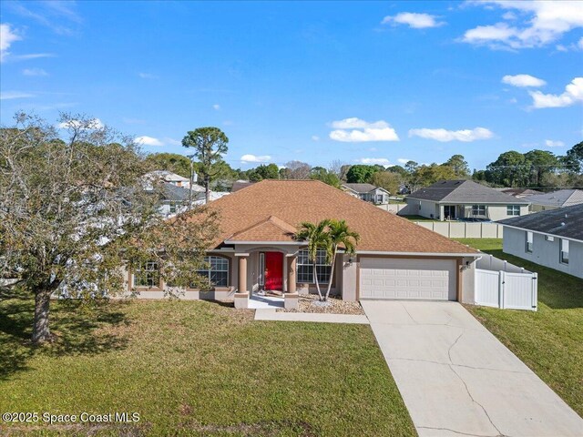 ranch-style home with driveway, a front lawn, an attached garage, and fence