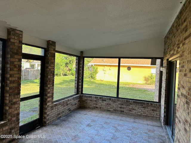 unfurnished sunroom featuring lofted ceiling