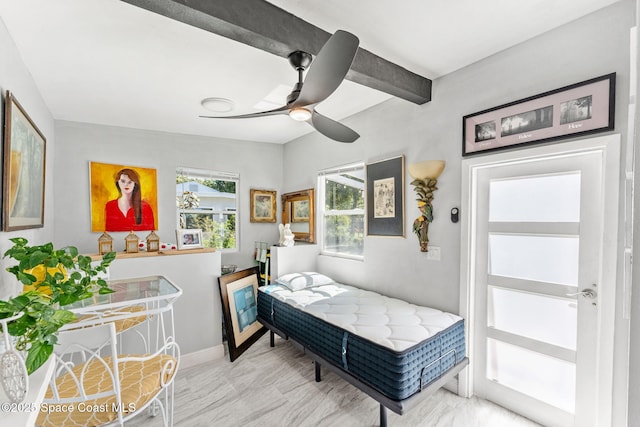 bedroom with a ceiling fan, beam ceiling, and baseboards