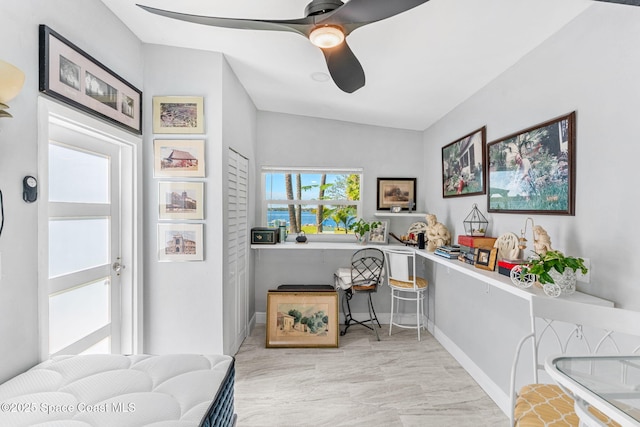 interior space featuring ceiling fan, lofted ceiling, and baseboards