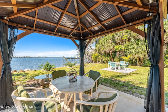 view of patio featuring a gazebo, outdoor dining area, and a water view