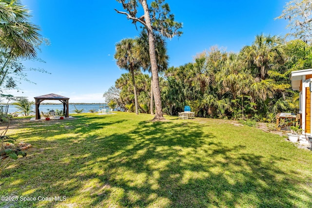 view of yard featuring a gazebo and a water view