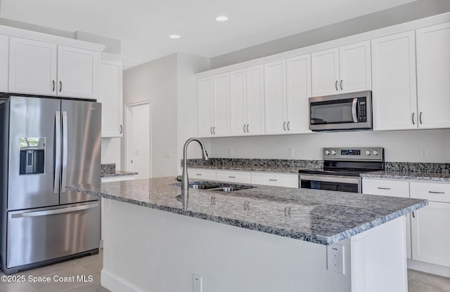 kitchen with appliances with stainless steel finishes, stone countertops, light tile patterned flooring, and a sink