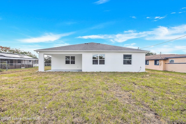 back of house featuring a patio, fence, a lawn, and stucco siding