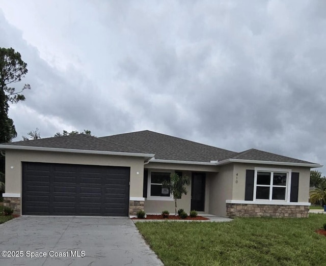 prairie-style home featuring a front lawn, concrete driveway, stone siding, and stucco siding