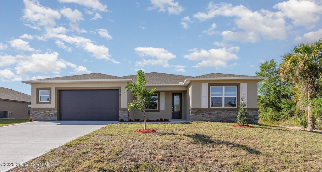 478 Hancock St SW, Palm Bay, FL 32908 - prairie-style house featuring a front yard, stone siding, concrete driveway, stucco siding, and an attached garage