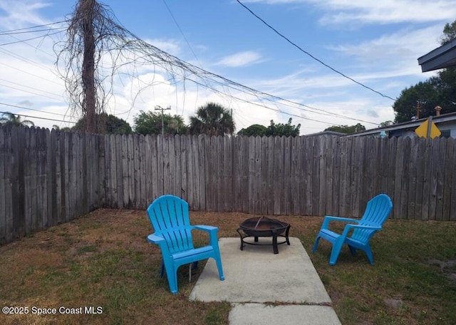 view of yard with a fenced backyard, a fire pit, and a patio