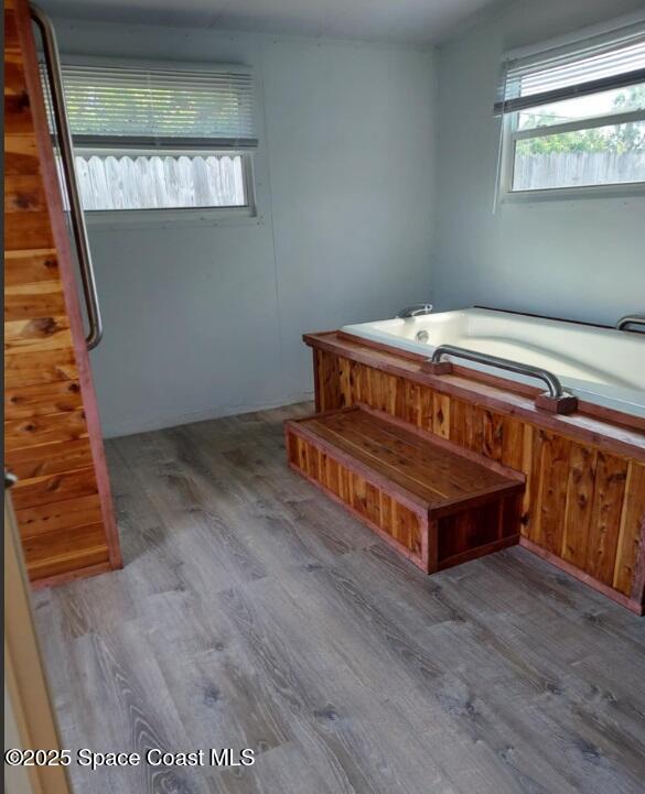 full bathroom with a garden tub and wood finished floors