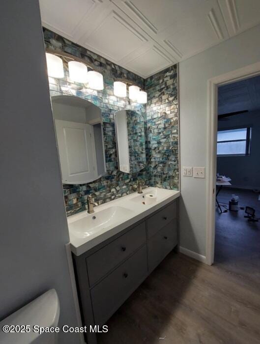 full bath with a sink, backsplash, toilet, and double vanity