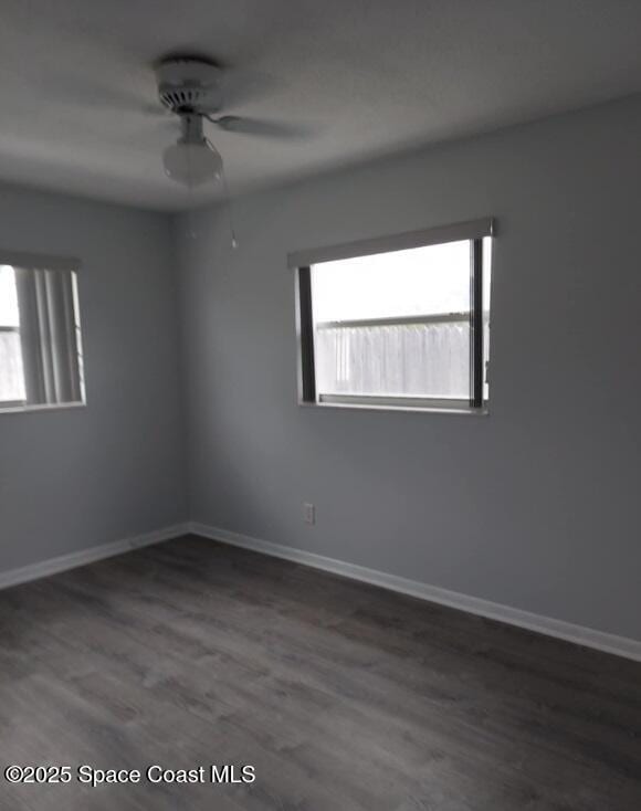 unfurnished room featuring a ceiling fan, baseboards, and wood finished floors