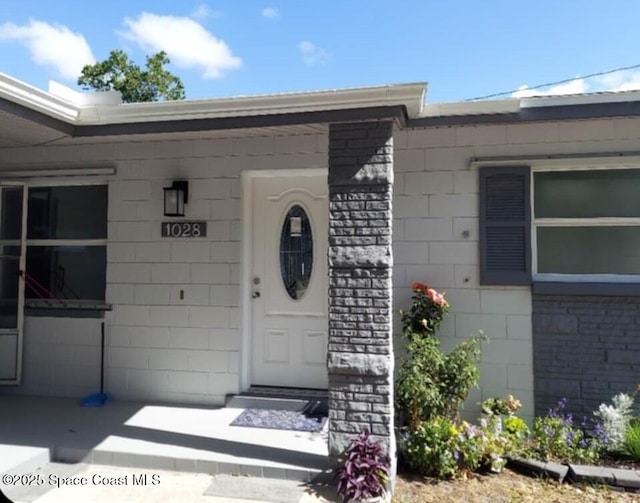 doorway to property featuring concrete block siding